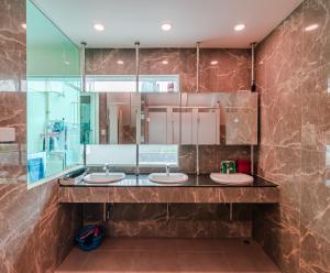 a bathroom with two sinks and a mirror at The Victory View in Bangkok +41 photos
