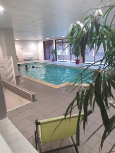 une grande piscine avec 2 personnes dans l'eau dans l'établissement Joli appartement T2 dans résidence avec piscine, hammam et parking gratuits, à Carcassonne