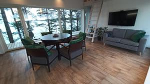 a living room with a table and chairs and a couch at Seaside cottage Rebase Kuur in Keibu +19 photos