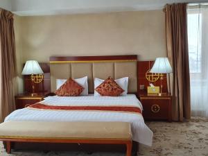 a bedroom with a large bed with two lamps at K Hostel in Ulaanbaatar +37 photos