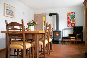 une salle à manger avec une table, des chaises et une cheminée dans l'établissement Ferienhaus auf Gut Weimarschmieden, à Fladungen
