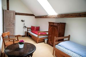 Zimmer mit 2 Betten, einem Tisch und einem Bett in der Unterkunft Ferienhaus auf Gut Weimarschmieden in Fladungen
