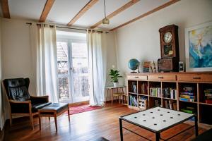 a living room with a book shelf and a clock at Ferienhaus auf Gut Weimarschmieden in Fladungen