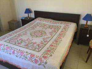 Una cama con una manta floral encima. en Ekali House Apartments, en Limassol