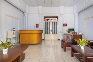a lobby with a desk and a welcome sign on the door at RedDoorz Syariah @ Bondowoso City Center in Bondowoso