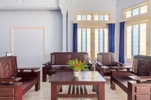 a room with benches and a table with a plant on it at RedDoorz Syariah @ Bondowoso City Center in Bondowoso