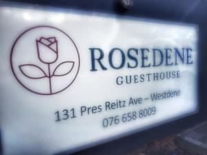 un letrero para una casa de huéspedes rosada en Rosedene en Bloemfontein