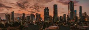 a city skyline with tall skyscrapers at sunset at Nostoi in Jakarta
