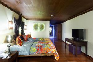 a bedroom with a bed and a flat screen tv at Tropica Bungalow Beach Hotel in Patong Beach