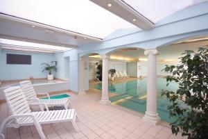 a swimming pool with two white chairs and a swimming pool at Imperial Hotel in Llandudno