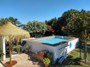 a small swimming pool in a yard with an umbrella at Villa de Limones in Chiclana de la Frontera