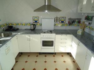 a white kitchen with a stove and a sink at Villa de Limones in Chiclana de la Frontera
