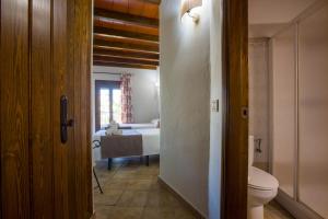 Hostal Valle Del Sol Alora في ألورا: حمام مع سرير ومرحاض في الغرفة
