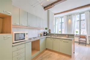 a kitchen with white cabinets and a microwave at The Hendrik House in Old Town Antwerp in Antwerp +43 photos