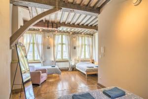 a living room with two beds and windows at The Hendrik House in Old Town Antwerp in Antwerp