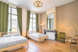 1 Schlafzimmer mit 2 Betten, einem Spiegel und einem Stuhl in der Unterkunft The Capital Street Lodge in Antwerpen