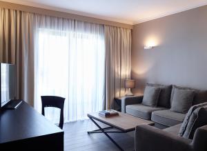 a living room with a couch and a table at Pelagos Suites Hotel & Spa in Kos