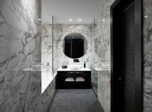 a bathroom with a sink and a mirror at Pelagos Suites Hotel & Spa in Kos