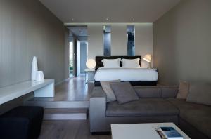 a large bedroom with a bed and a couch at Pelagos Suites Hotel & Spa in Kos