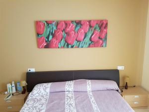 ein Schlafzimmer mit einem Bett und einem rosafarbenen Tulpenbild in der Unterkunft CAL50 in Calafat + 28 Fotos