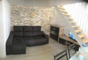 salon z czarną kanapą i schodami w obiekcie Tenerife Costa del silencio w mieście Costa Del Silencio