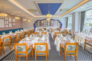 a dining room with white tables and wooden chairs at Sherwood Exclusive Lara in Lara