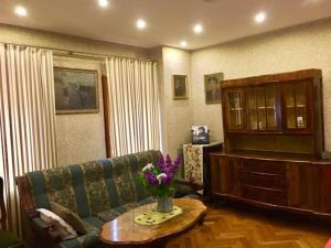 a living room with a couch and a table with flowers at Willa Danusia in Milanówek
