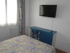 um quarto com uma cama e uma TV na parede em Hotel La Torre em Calella de Palafrugell