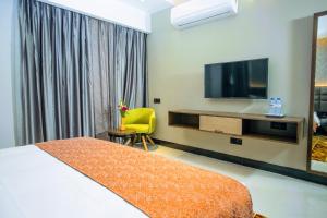 a hotel room with a bed and a flat screen tv at Hotel Omni Residency Dhaka in Dhaka