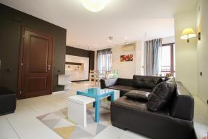sala de estar con sofá negro y mesa en Trendy & Deluxe Apartment, en Plovdiv