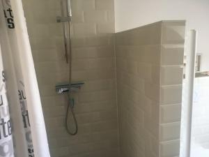 a shower with a shower head in a bathroom at Pacific, spectacular seaview in Bergen aan Zee