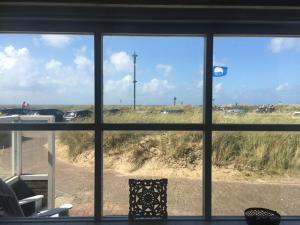 a view of a beach from a window at Pacific, spectacular seaview in Bergen aan Zee +9 photos