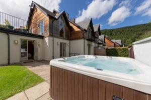 a hot tub in the backyard of a house at Mains of Taymouth Country Estate 5* Houses in Kenmore