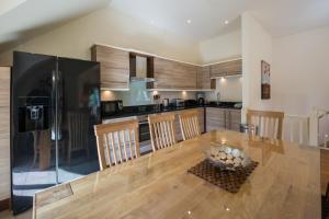 a kitchen with a wooden table and a dining room at Mains of Taymouth Country Estate 5* Houses in Kenmore