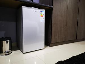 a white refrigerator in a kitchen next to a cabinet at Green Olive Residences in Bethlehem