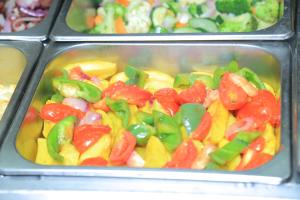 a tray of food with peppers and other vegetables at Tiffany Diamond Hotels Ltd - Indira Gandhi street in Dar es Salaam