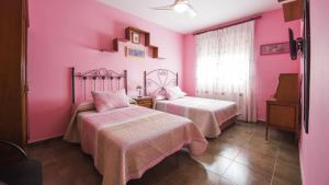 a room with two beds in a pink room at Flor de la Jara in Cobisa +74 photos