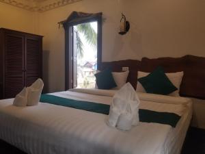 Een bed of bedden in een kamer bij Alana Luang Prabang