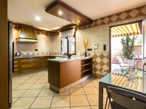 a large kitchen with a counter and a table at Casa jofrais in La Zubia