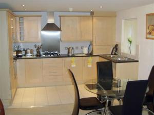 a kitchen with a table and chairs and a counter top at Hidden Gem in Manchester
