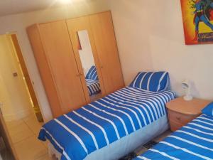 a bedroom with a blue and white striped bed at Hidden Gem in Manchester