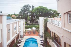 vista sulla piscina in un cortile tra due edifici di Solares Hotel & Spa ad Alta Gracia