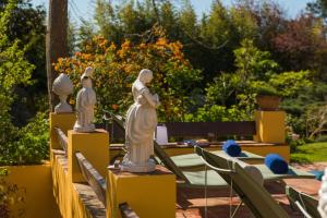 a group of statues sitting on tables in a garden at Quinta das Pedras - Small Luxury Guesthouse in Sintra