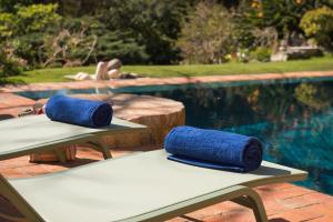 two blue yoga mats sitting on a table next to a pool at Quinta das Pedras - Small Luxury Guesthouse in Sintra +40 photos