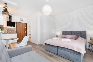 a bedroom with a bed and a living room at Gold Flamingo Apartament by Renters in Międzyzdroje