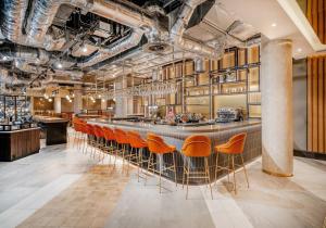 a bar in a restaurant with orange chairs at Novotel Leicester in Leicester