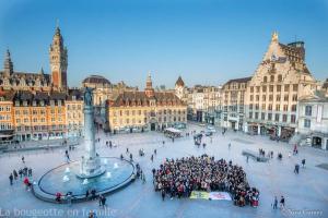 Eine Menschenmenge auf einem Platz in einer Stadt mit einem Uhrturm in der Unterkunft Hyper Centre LILLE appt. 6 personnes confortable pour famille ou amis in Lille