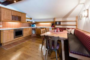 una cocina con armarios de madera y una mesa con sillas. en Haus Andrea Unterberger, en Flachau