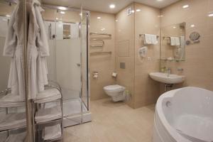 a bathroom with a toilet, sink, and bathtub at Vladykino Apart-Hotel in Moscow