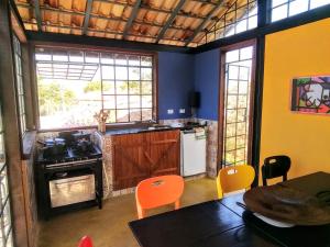 uma cozinha com cadeiras laranja e uma mesa num quarto em Recanto das Acácias em Guararema